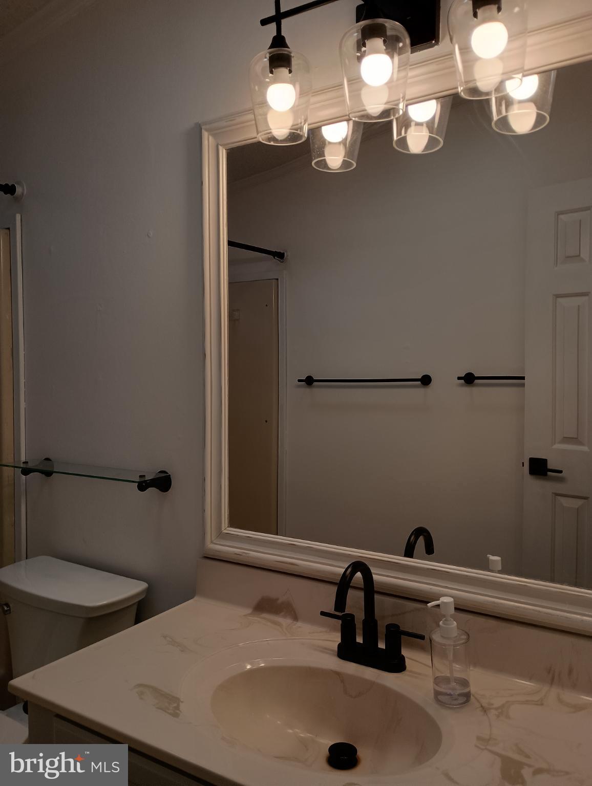 32217 Sandpiper Drive Lewes, DE 19958 - Photo 17 of 21 a bathroom with a sink and a mirror