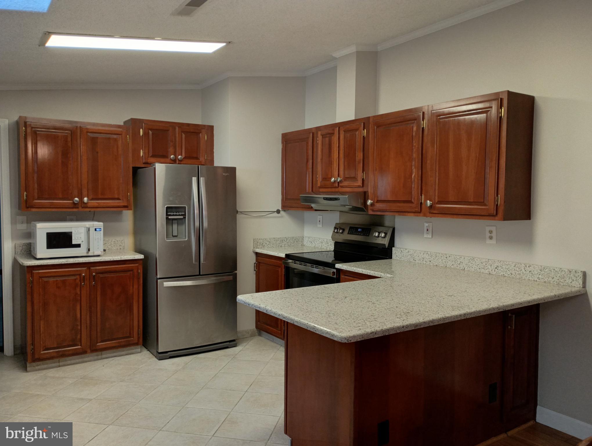 32217 Sandpiper Drive Lewes, DE 19958 - Photo 4 of 21 a kitchen with a refrigerator a microwave a sink and a stove