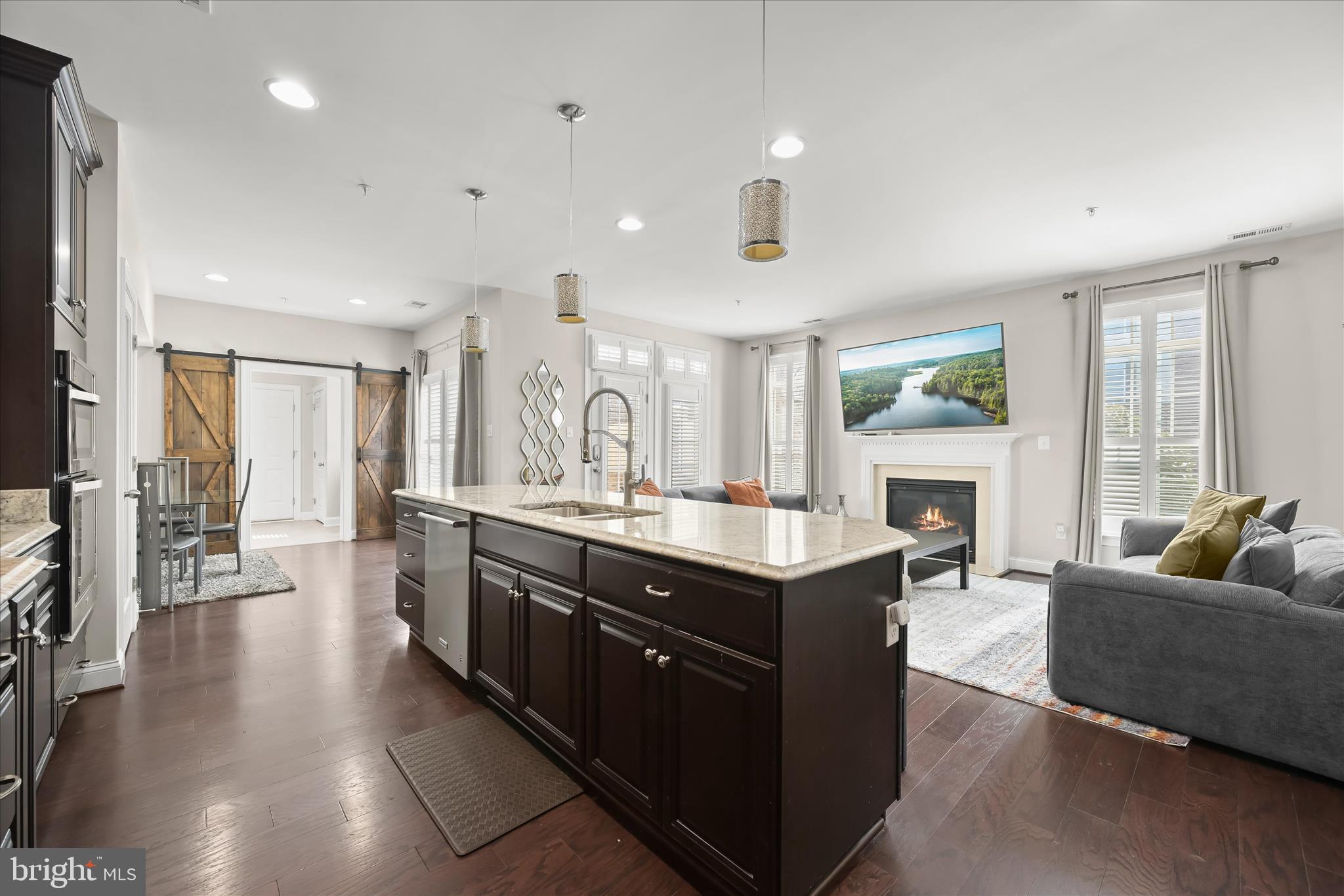 11295 Market Street Fulton, MD 20759 - Photo 61 of 62 a large living room with stainless steel appliances granite countertop a couch a fireplace a flat screen tv and a window