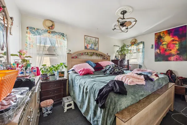 a bedroom with bed and a chandelier