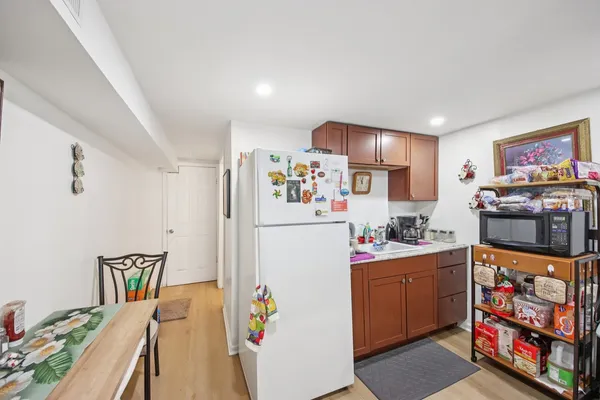 a kitchen with stainless steel appliances a refrigerator a sink a stove a chimney a refrigerator and cabinets