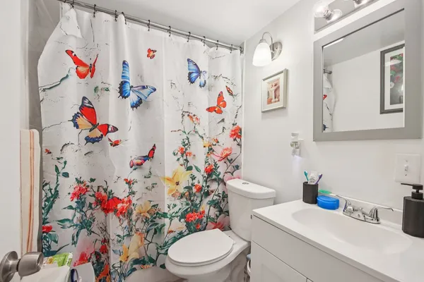 a bathroom with a toilet and a shower curtain