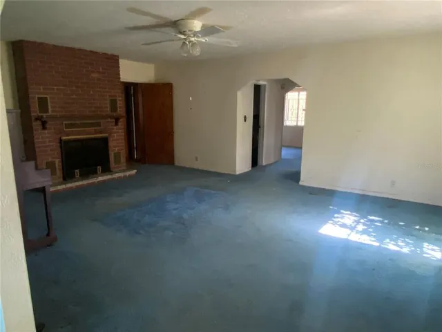 a view of empty room with fireplace and fan
