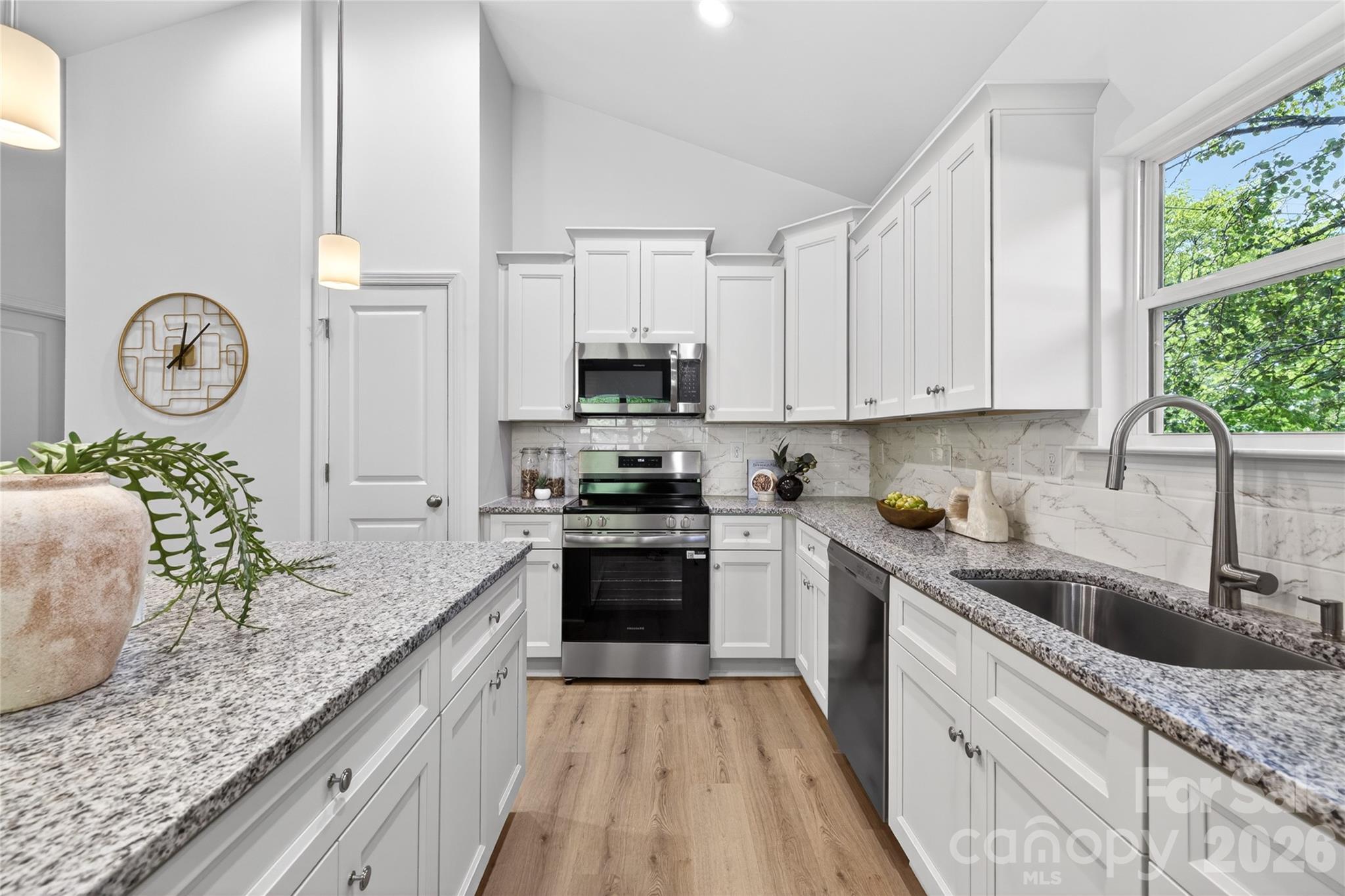 9212 Moores Chapel Road Charlotte, NC 28214 - Photo 5 of 23 a kitchen with granite countertop a sink a stove top oven and cabinets