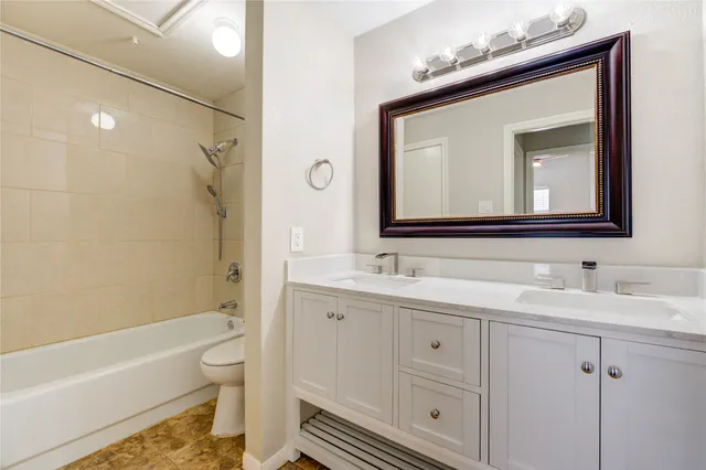 a bathroom with a toilet sink vanity tub and shower