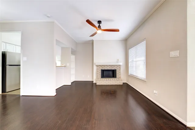 a view of empty room with wooden floor and fireplace