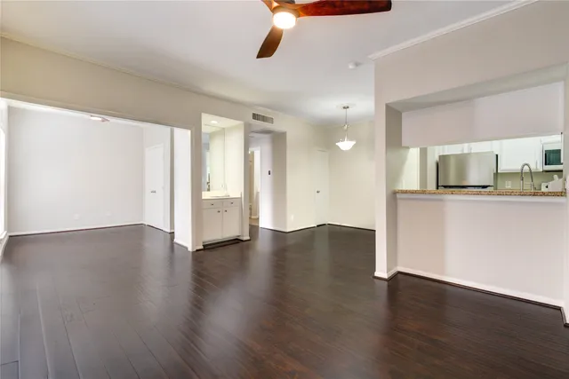 a view of a kitchen with a fridge wooden floor and a window
