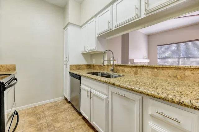 a kitchen with stainless steel appliances granite countertop a sink and cabinets