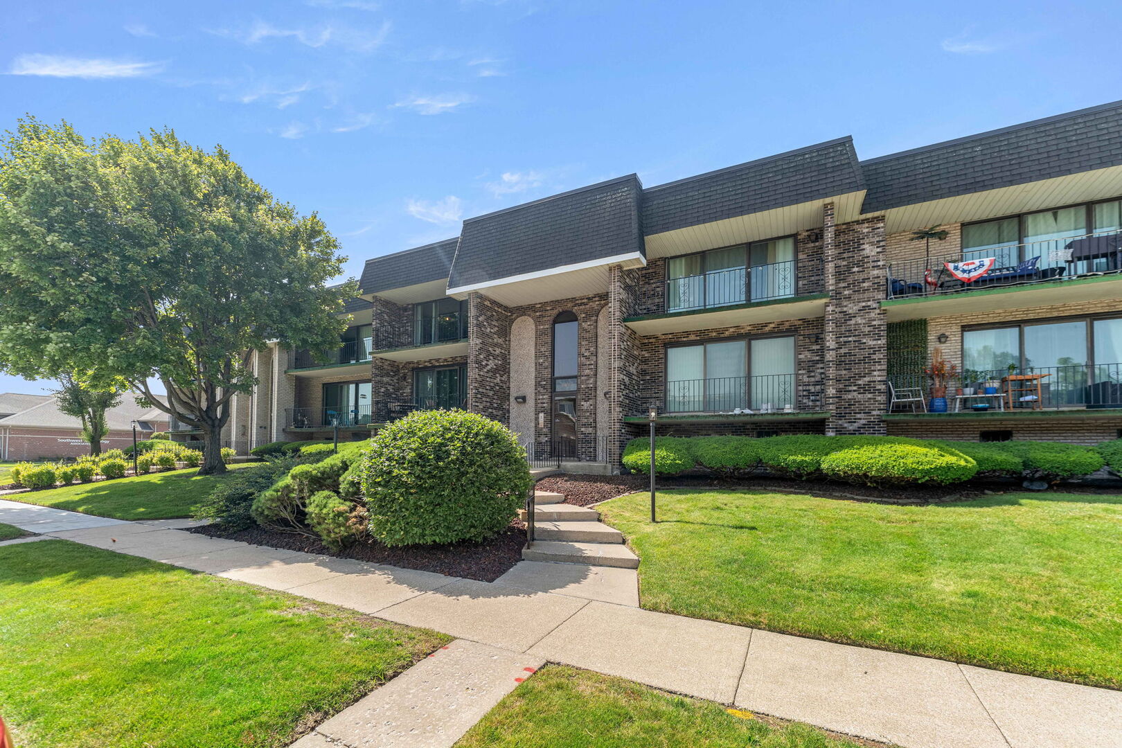 9122 South Pulaski Road, Unit 2E Oak Lawn, IL 60453 - Photo 2 of 16 a front view of a brick house with a yard