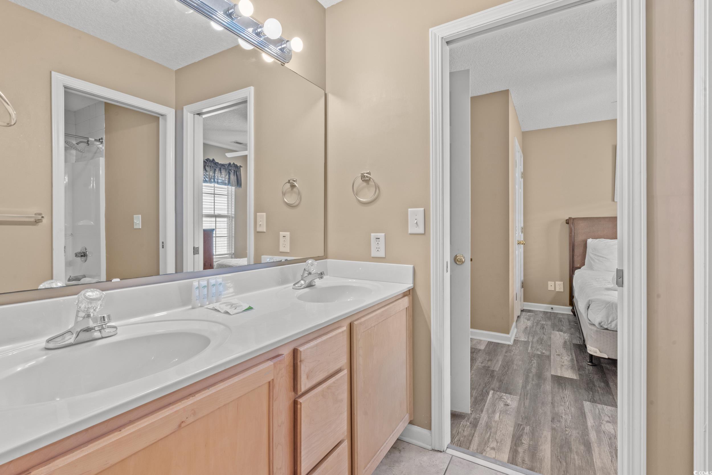 113 B 15th Avenue South Surfside Beach, SC 29575 - Photo 22 of 40 Ensuite bathroom with shower / washtub combination, double vanity, light wood-style flooring, and a textured ceiling