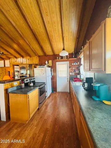a kitchen with stainless steel appliances granite countertop a sink a stove and a wooden floors