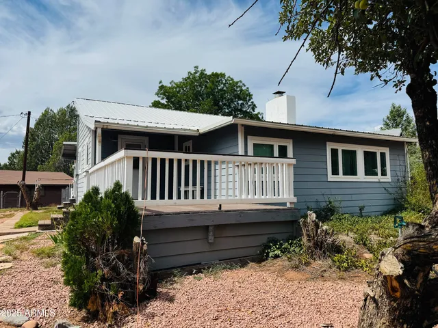 a view of a house with wooden deck and furniture
