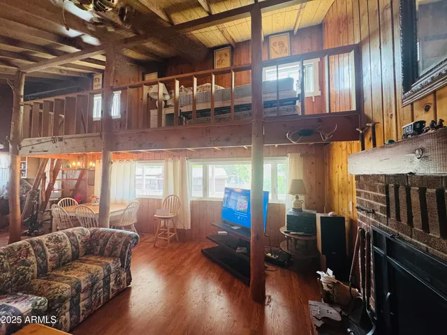 a living room with furniture or chandelier and a wooden floor
