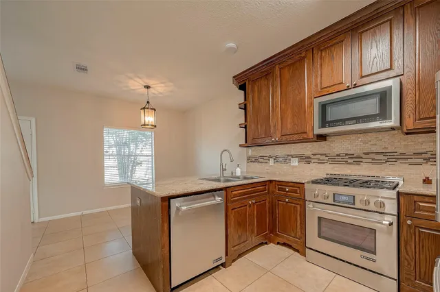 a kitchen with stainless steel appliances granite countertop a stove microwave and sink