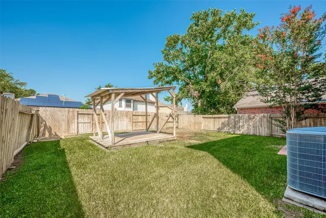 a view of a backyard with a garden and deck