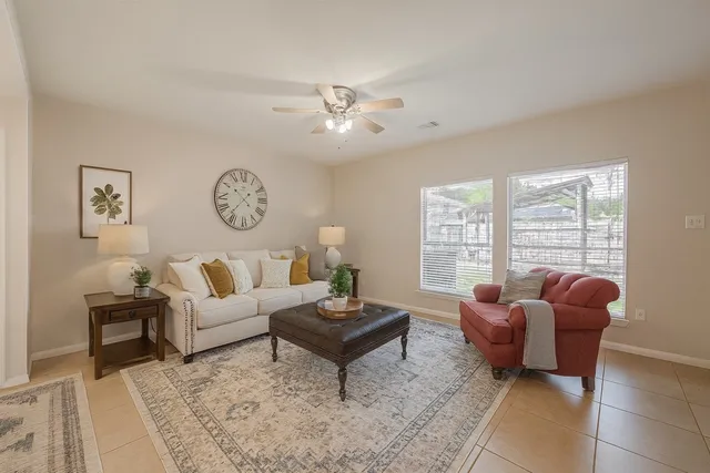 a living room with furniture a clock and a large window