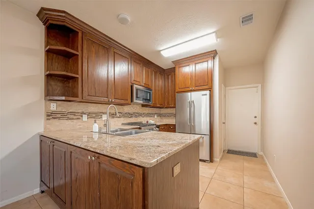 a kitchen with a sink refrigerator and cabinets