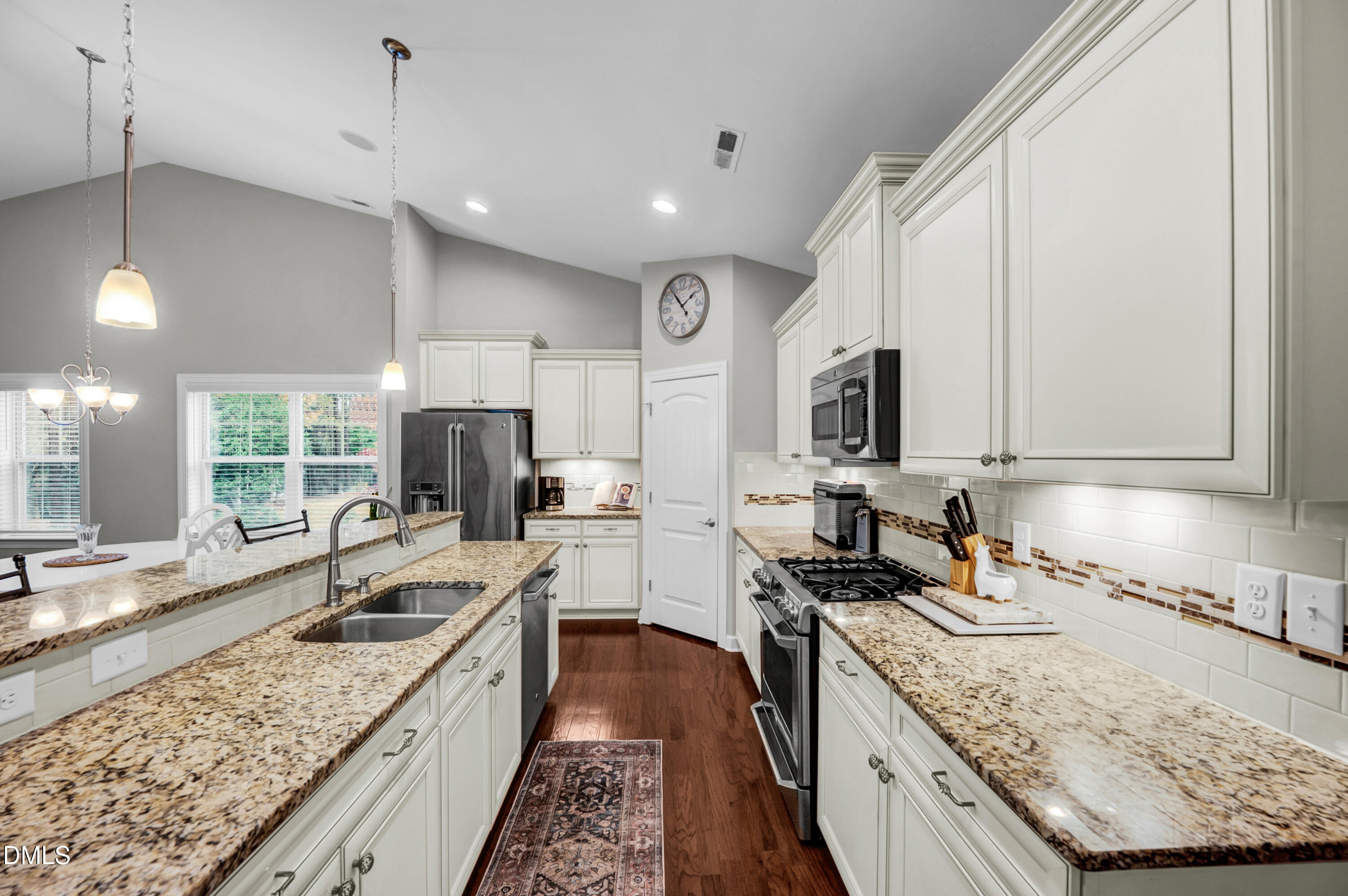 8621 Jordan Meadow Drive Fuquay-Varina, NC 27526 - Photo 8 of 55 a large kitchen with a stove a sink a counter space and cabinets