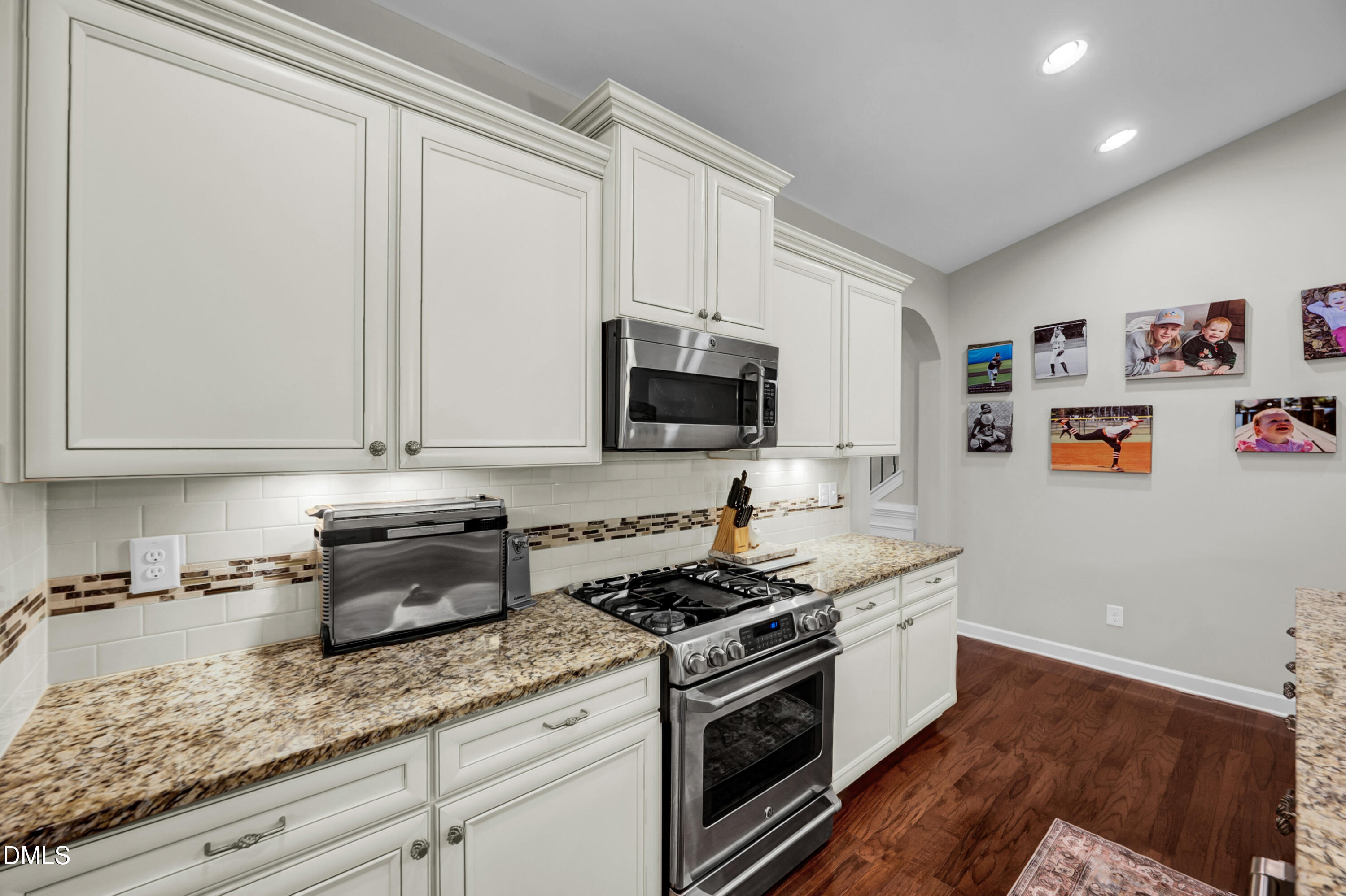 8621 Jordan Meadow Drive Fuquay-Varina, NC 27526 - Photo 11 of 55 a kitchen with stainless steel appliances granite countertop a sink a stove and a microwave