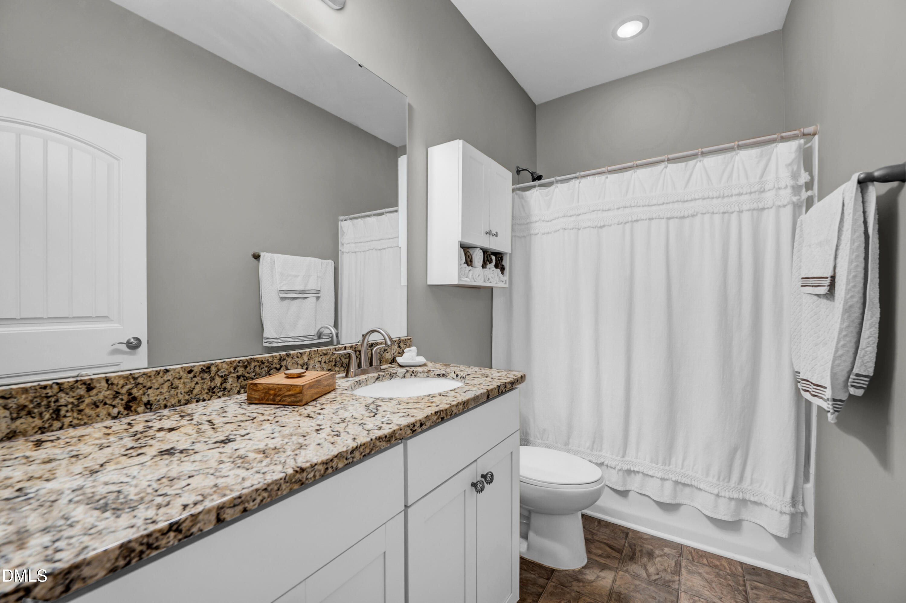 8621 Jordan Meadow Drive Fuquay-Varina, NC 27526 - Photo 22 of 55 a bathroom with a granite countertop sink and a mirror