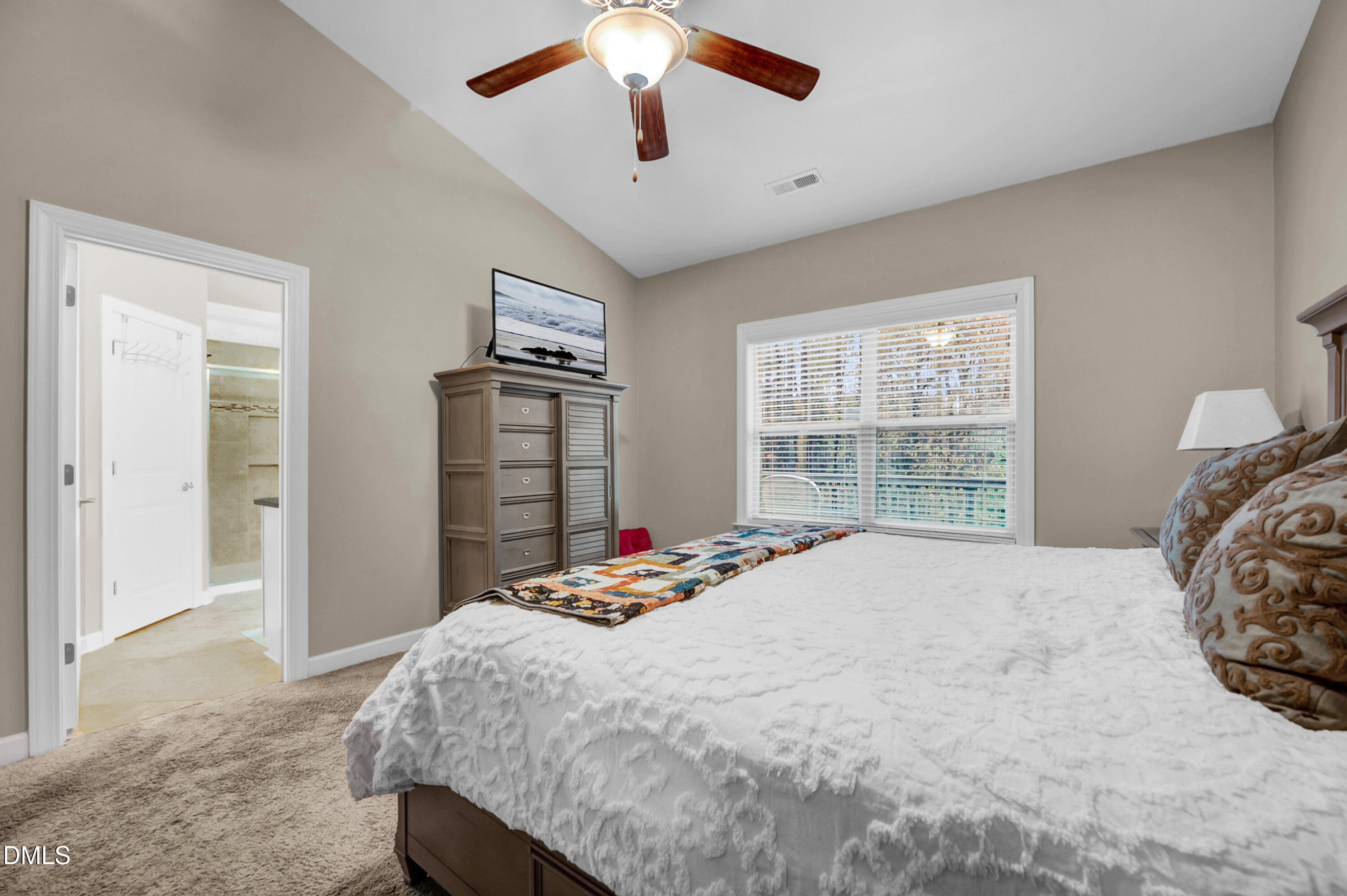 8621 Jordan Meadow Drive Fuquay-Varina, NC 27526 - Photo 25 of 55 a bed sitting in a bedroom next to a window and a chandelier