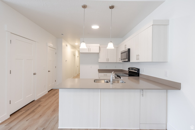 693 West 4500th South, Unit O304 Mapleton, UT 84664 - Photo 14 of 16 Kitchen with a peninsula, hanging light fixtures, light countertops, stainless steel appliances, and light wood-style flooring