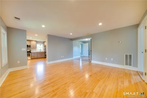 a view of empty room with wooden floor