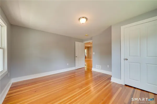 a view of empty room with wooden floor and entryway