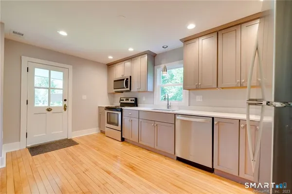 a kitchen with granite countertop a stove top oven sink and cabinets