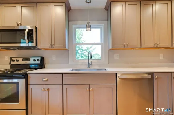 a kitchen with stainless steel appliances granite countertop a sink a stove and cabinets
