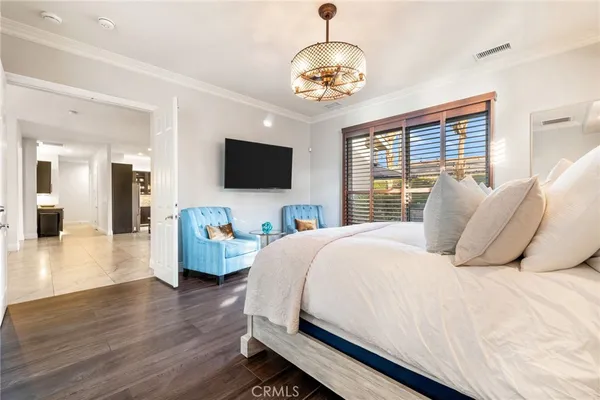 a spacious bedroom with a bed and a flat screen tv