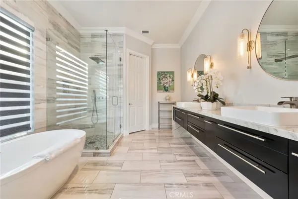 a spacious bathroom with a double vanity sink a mirror and a bathtub