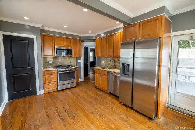 a kitchen with stainless steel appliances granite countertop a refrigerator a stove and a sink