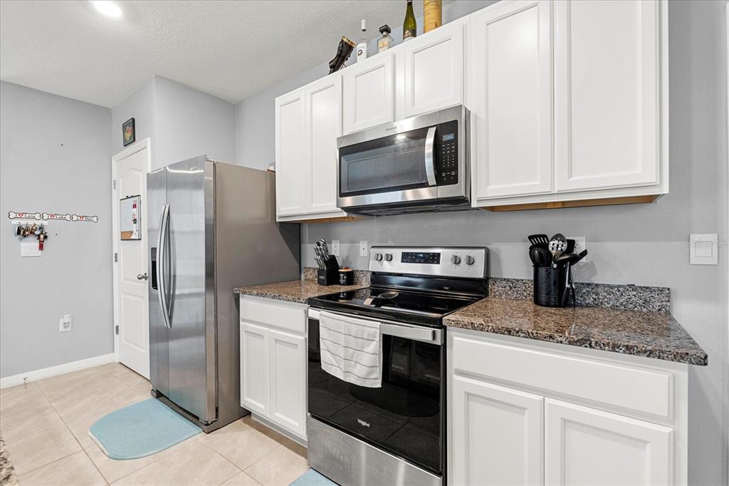 6895 Botanic Boulevard Harmony, FL 34773 - Photo 6 of 31 a kitchen with stainless steel appliances granite countertop a refrigerator stove and microwave