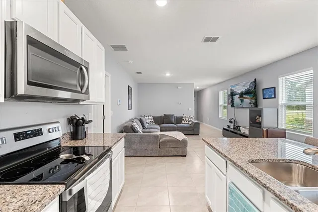 a kitchen with stainless steel appliances granite countertop a stove and a microwave