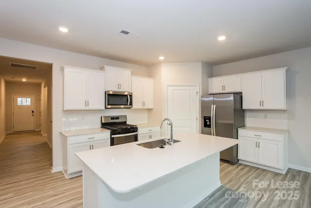 a kitchen with refrigerator cabinets and wooden floor