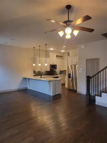 a kitchen with kitchen island granite countertop a stove and a wooden floor