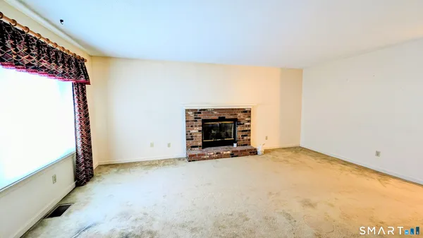 a view of an empty room with a fireplace