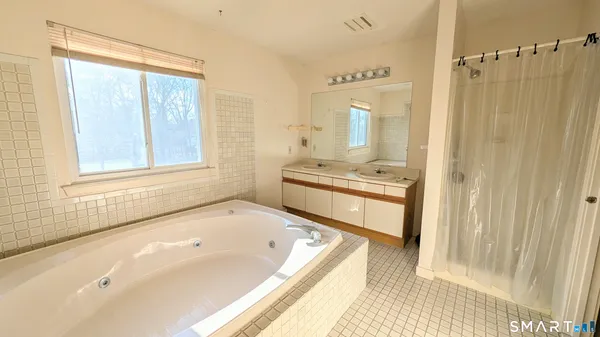 a bathroom with a tub sink and mirror