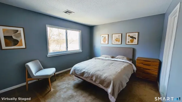 a bed sitting in a bedroom next to a window