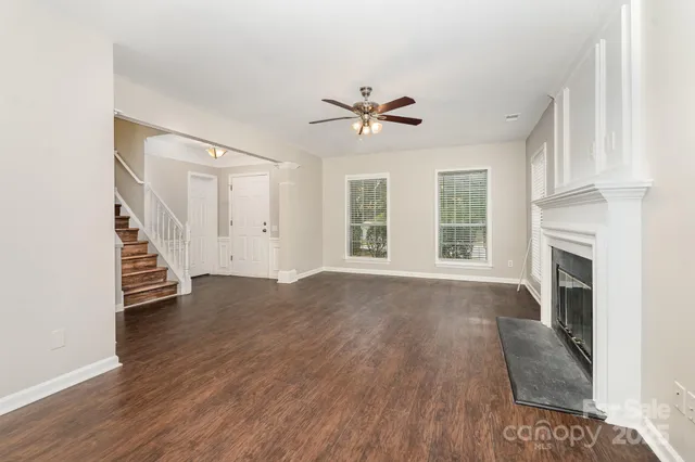 a view of empty room with fireplace and wooden floor