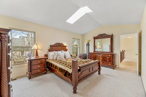 a bedroom with a bed and a large window with the dresser
