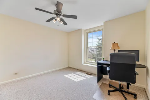a view of a workspace with furniture and a window