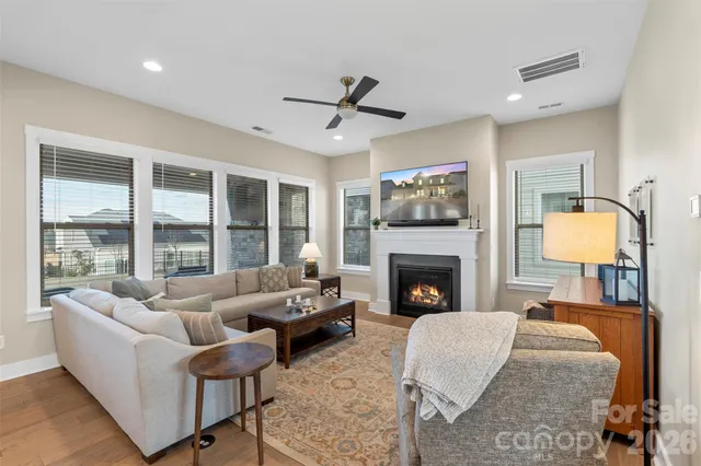 a living room with furniture a fireplace and a floor to ceiling window