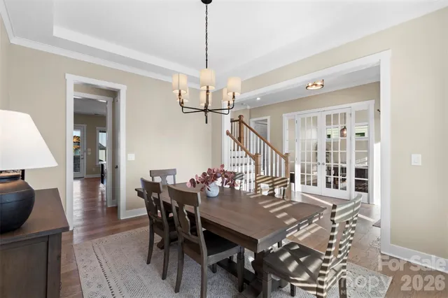 a view of a dining room and livingroom with furniture wooden floor a chandelier