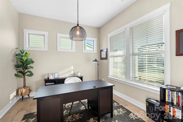 a view of a workspace with furniture and a window