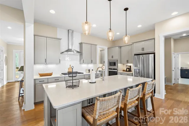 a kitchen with stainless steel appliances kitchen island granite countertop a kitchen island a stove a dining table and chairs