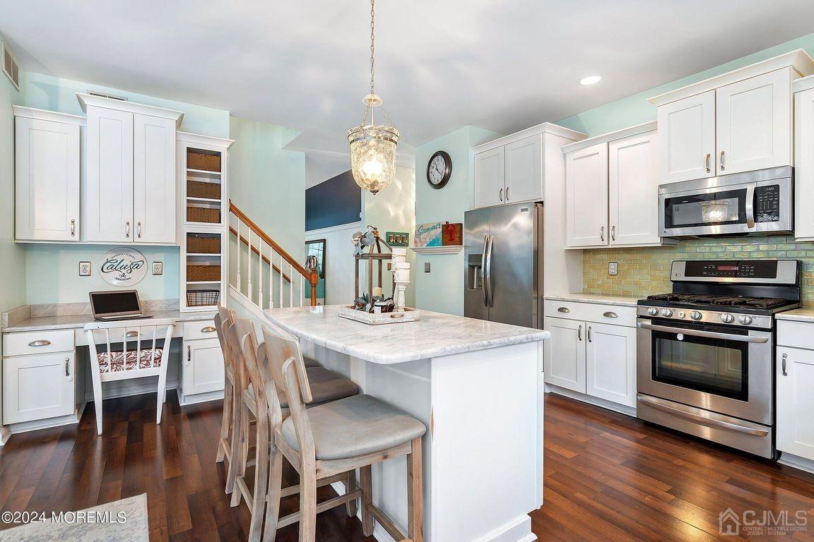 8 Williams Street Barnegat, NJ 08005 - Photo 21 of 64 a kitchen with stainless steel appliances granite countertop a stove a refrigerator a kitchen island a dining table and chairs with wooden floor