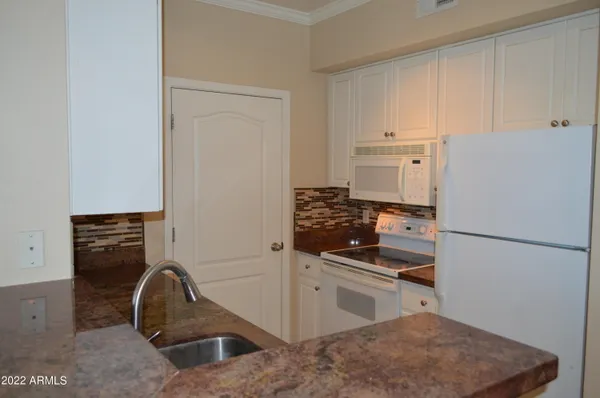 a kitchen with a refrigerator and a stove top oven
