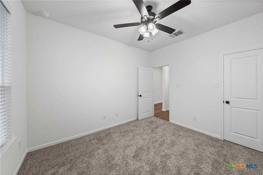 8011 Pineridge Way Temple, TX 76502 - Photo 17 of 32 an empty room with a chandelier fan and closet